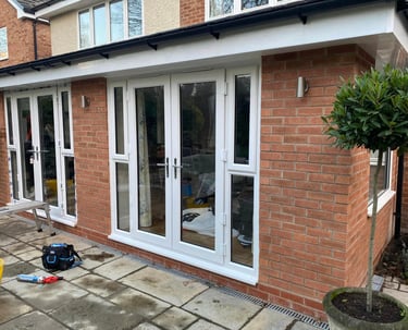 a house with a patio area, double french doors fitted into blockwork