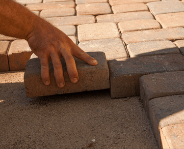 a person is placing bricks on a brick wall