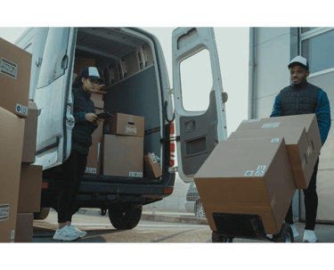 a man and woman moving boxes to a moving house