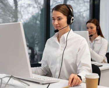 a woman in a white shirt and headphones on a computer