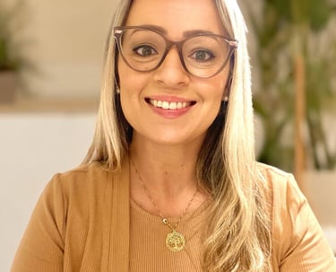 mulher loira de óculos e com um colar dourado sorrindo