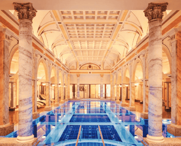 a large luxury indoor swimming pool with a blue tiles
