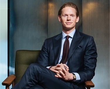a man in a suit and tie sitting in a chair