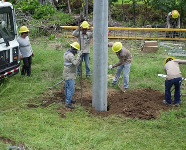 grupo de hombres haciendo un hoyo para instalacion de poste electrico