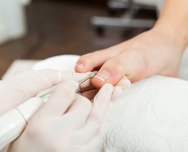 a person is getting their nails done by a pedicuring