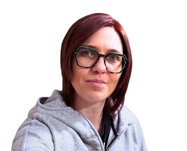 Professional woman with red hair wearing stylish green-rimmed glasses and a grey hoodie.
