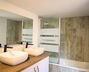 Salle de bain équipée avec baignoire et double vasque pour séjour professionnel.