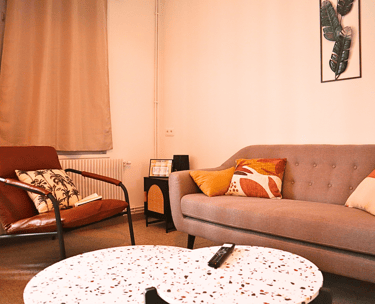 Coin salon cosy avec canapé et fauteuils dans hébergement pour équipes en mission.