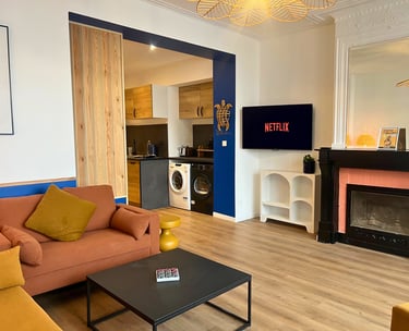 Séjour lumineux avec TV et cuisine équipée dans logement meublé pour pros.