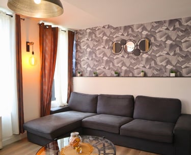 Salon moderne avec canapé d’angle confortable dans logement meublé.