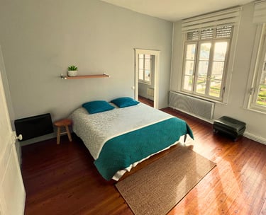 Chambre double spacieuse avec lit confortable et parquet dans maison meublée.