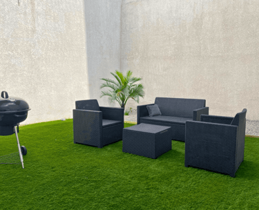 Espace extérieur privatif avec salon de jardin et barbecue dans logement professionnel.