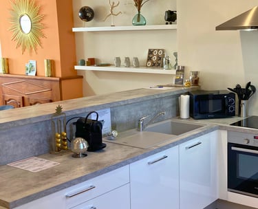 Cuisine moderne équipée avec électroménagers et plan de travail pratique.