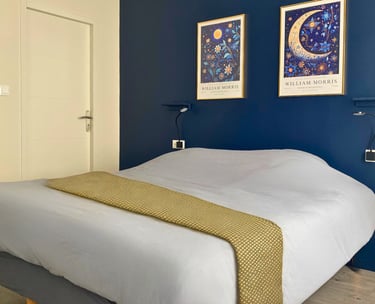 Chambre double cosy d’appartement meublé avec lit confortable et décoration élégante.