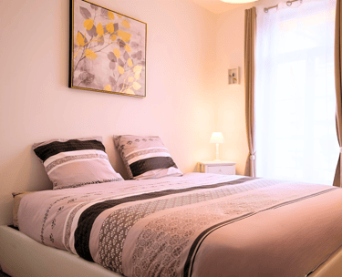 Chambre double cosy avec literie confortable dans hébergement meublé.
