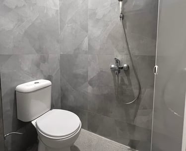 Kamar mandi dalam di Kos Si Bos dilengkapi toilet duduk modern, wastafel, desain bersih minimalis