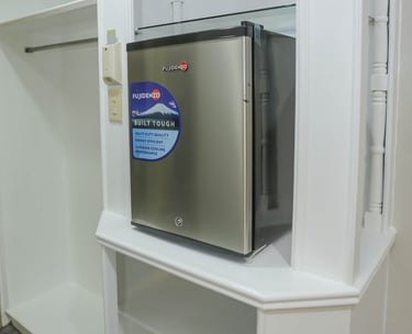 a mini fridge and cabinets