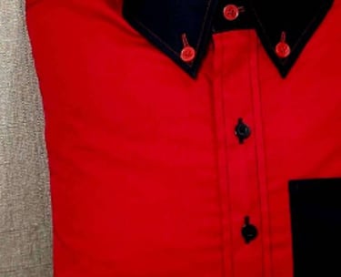a red shirt pillow sitting on a chair