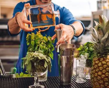 a man is making a tequila cocktail at a bar with a bottle of Uno Tequila