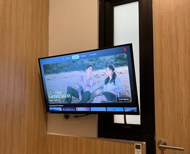 Smart TV di kamar Kos Si Bos Surabaya Barat lengkap dengan akses Netflix untuk hiburan penghuni.