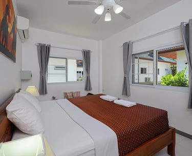 Master bedroom with king size bed and air conditioning at Yanui Apartments