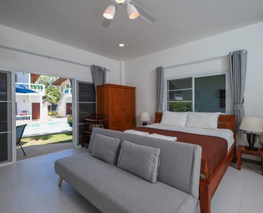 Modern studio apartment interior with king bed and seating area