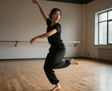 A dancer in mid-motion in a spacious, light-filled North American dance studio with wooden floors, conveying serene movement and grace.