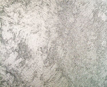 A cool silver paint sample showing off its shimmering grainy texture.