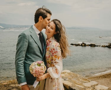 Groom kisses bride on the cheek by the sea — fine art wedding photography South of France