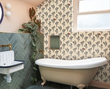 Modern bathroom featuring a clawfoot tub, cactus print wallpaper, and green herringbone tiles.