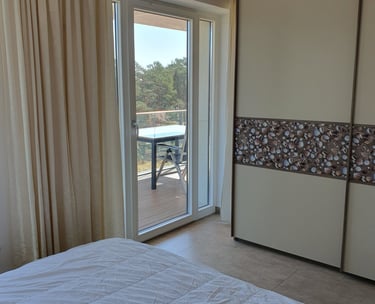 Blick über das Doppelbett auf den Balkon im 1. Schlafzimmer