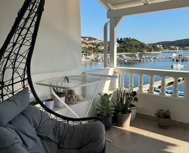Hängesessel auf einem Balkon mit Blick auf Boote und das Meer in Kampor auf Rab
