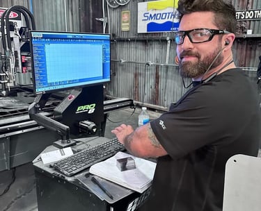 don abenante technician using a CNC machine control console in a fabrication workshop.