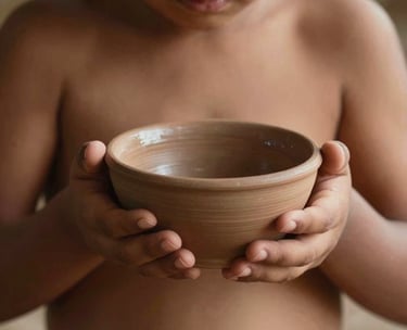 A close-up shot of a child's hands in a South American setting, carefully holding a small clay bowl during a tea ritual. The lighting is warm and organic, highlighting the wabi-sabi texture of the ceramics and the soft skin. Minimalist and aesthetic composition.