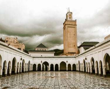 a clock tower in a courtyard with a clock tower in the background