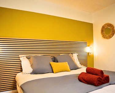 Chambre double avec literie confortable et déco colorée pour séjour professionnel.