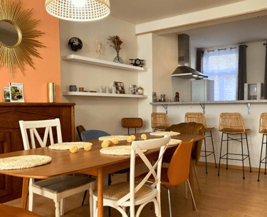 Salle à manger conviviale avec table familiale et cuisine ouverte équipée.