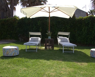 Private garden with sun loungers and umbrella in luxury Sicilian seaside villa