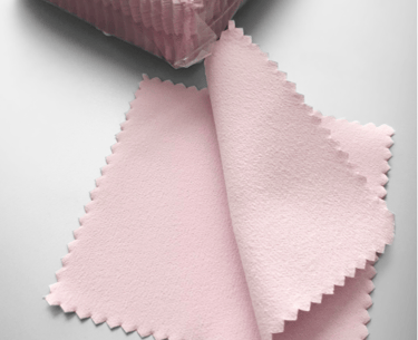 a pink and white cloth with a pink ribbon