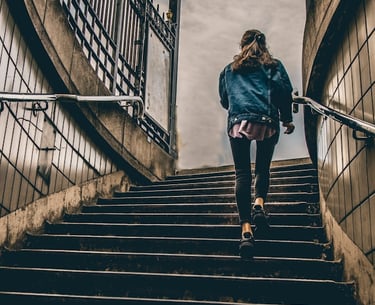 A woman engaging in vigorous incidental physical activity by running up a staircase.