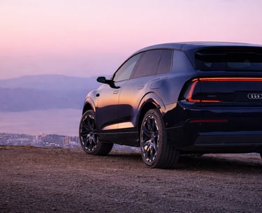 AUDI E7X SUV elétrico visto de traseira ao pôr do sol com design moderno e iluminação LED