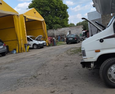 Campervan parked in a dusty auto repair lot in a small Polish town,