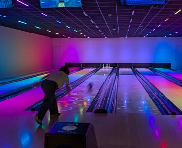 Bowling ball rolling down lane during a friendly family match.
