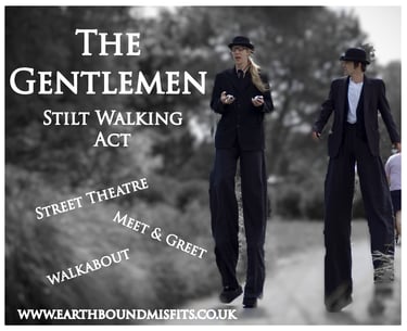 The Gentlemen stilt walking act performing street theatre and walkabout entertainment in black suits.