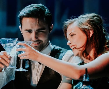 a man and woman are drinking a drink in theater performance