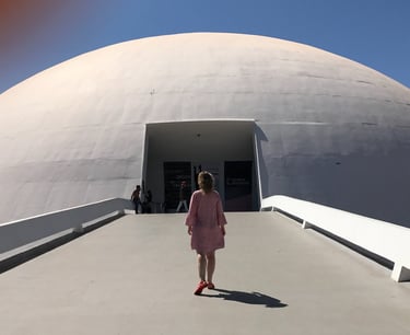 a woman in a pink dress walking down a walkway