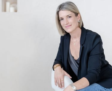 Yvonne seated in a therapy office, neutral background, relaxed portrait.