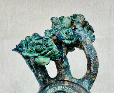 A ceramic plant-like sculpture glazed in green, blue and brown tones
