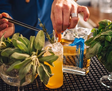 a man is preparing to make a tequila cocktail with a bottle of uno tequila añejo in the back