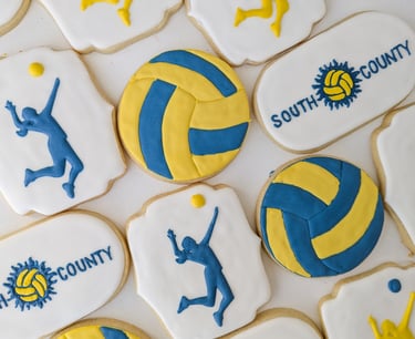 Sugar cookies for South County volleyball designed with volleyballs, girls serving, and team logo